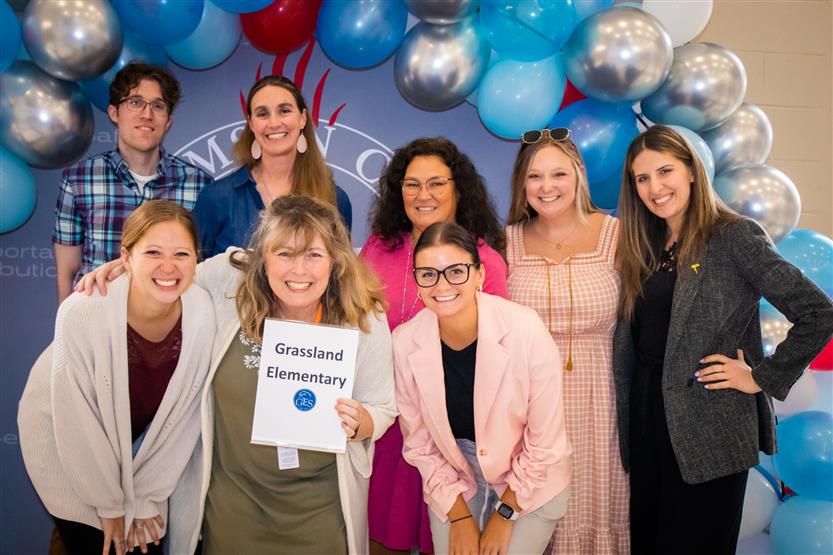 A group of teachers smile